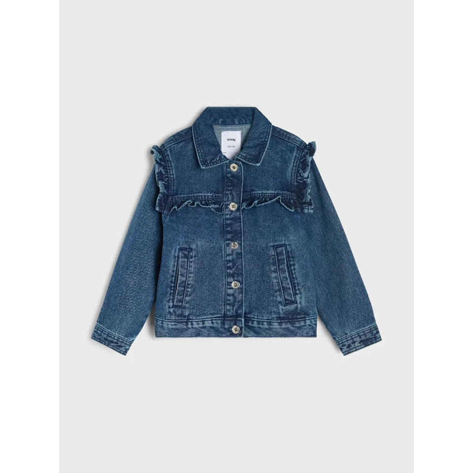 A blue denim jacket for girls, featuring ruffle details across the chest and shoulders, buttoned front, and front patch pockets, shown flat on a light gray background.