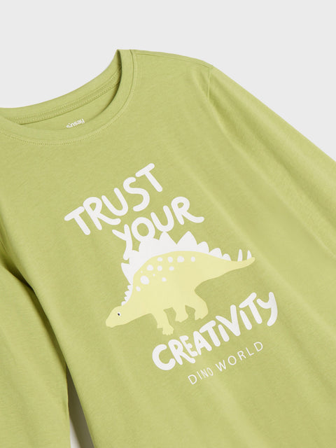 Green long-sleeve shirt with dinosaur graphic and text on a white background