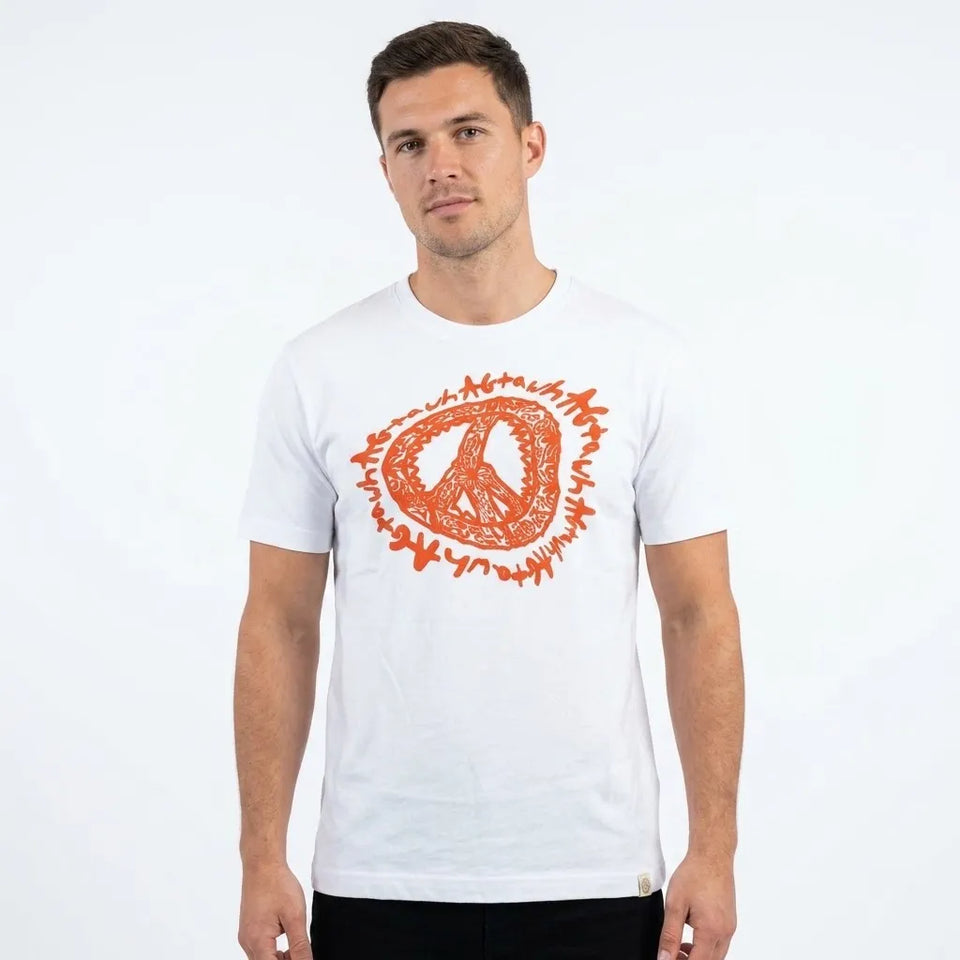 A man wearing a white crewneck t-shirt with a prominent orange graphic on the chest, set against a plain white studio background.
