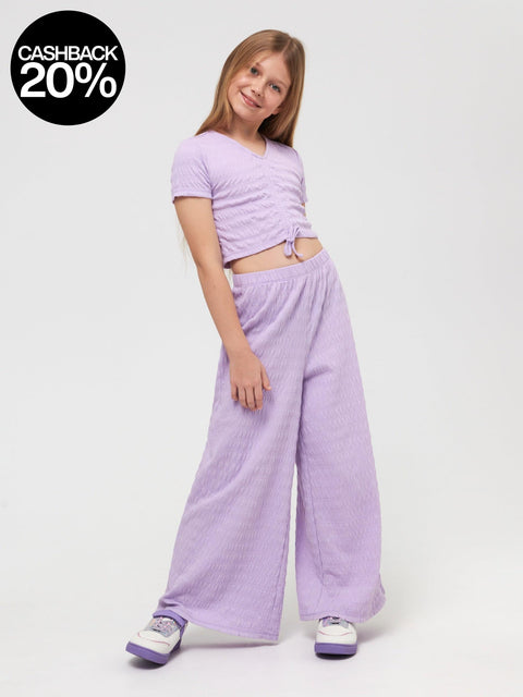 Young girl wearing a purple outfit on a white background