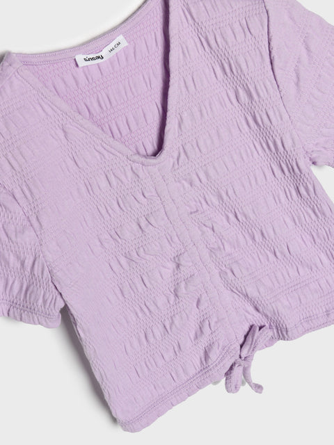 Purple textured top with a brand label on a white background