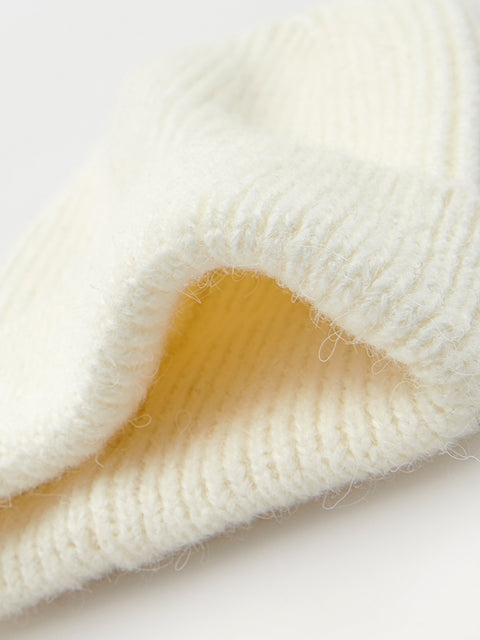 Close-up of a textured white fabric with a yellow patch on a light background