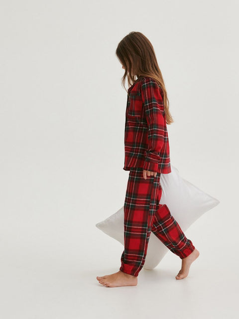 Person wearing red plaid pajamas on a white background