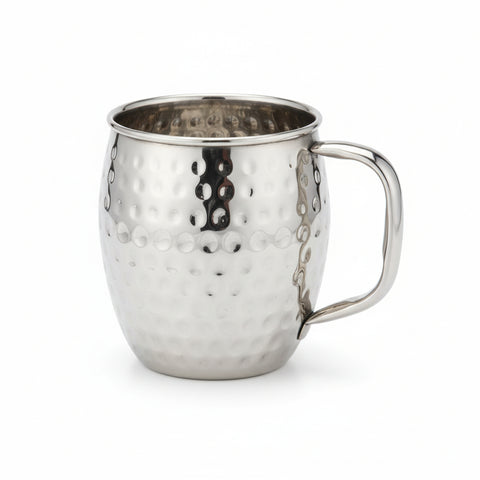 Metallic pot with decorative patterns on a desk next to a computer monitor