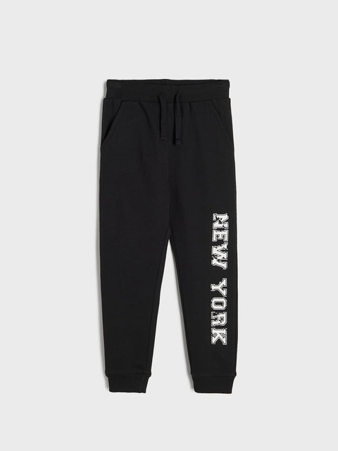 Black sweatpants with 'New York' text on a light gray background