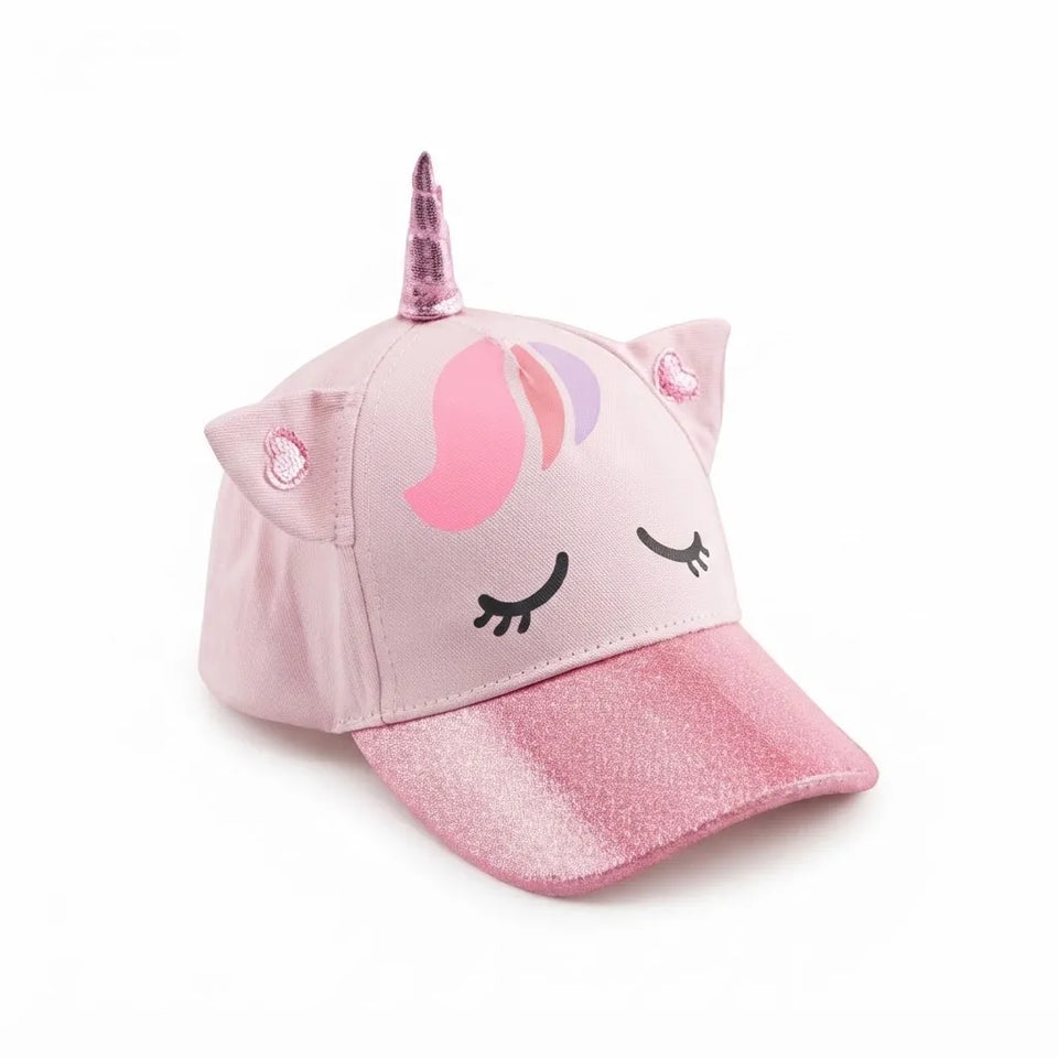 A pink unicorn-themed baseball cap with a glittery brim, a pink horn, cat ears, and a sleeping unicorn face graphic on the front, shown on a white background.