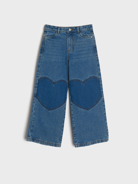Blue denim jeans with heart-shaped cutouts on a white background