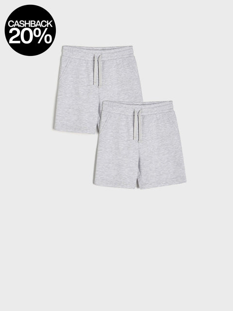 Two pairs of gray shorts on a white background