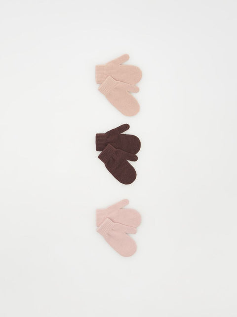 Set of three baby socks in pink, brown, and beige on a white background