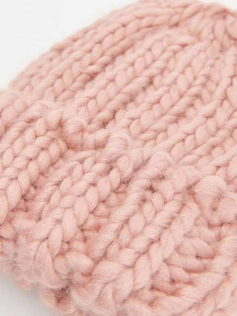 Close-up of pink knitted yarn on a white background