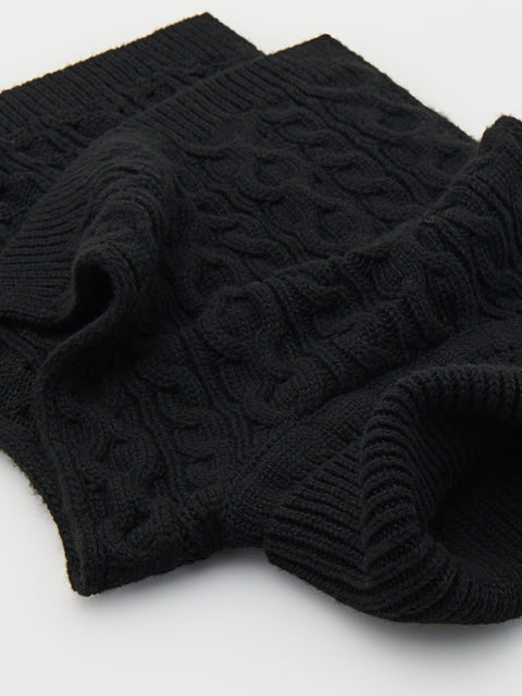 Black cable knit sweater on a light gray background