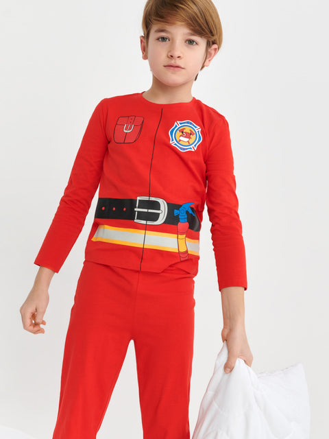 Child wearing a red firefighter costume with a white background