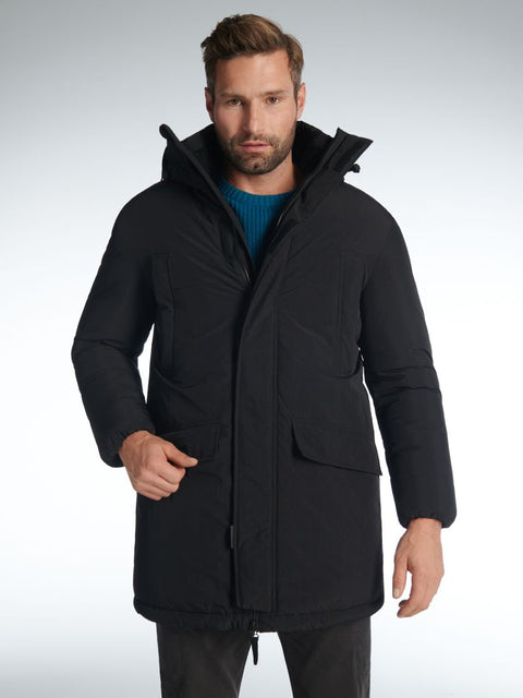 Man wearing a black coat on a gray background