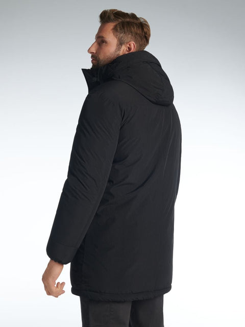 Man wearing a black coat on a light gray background