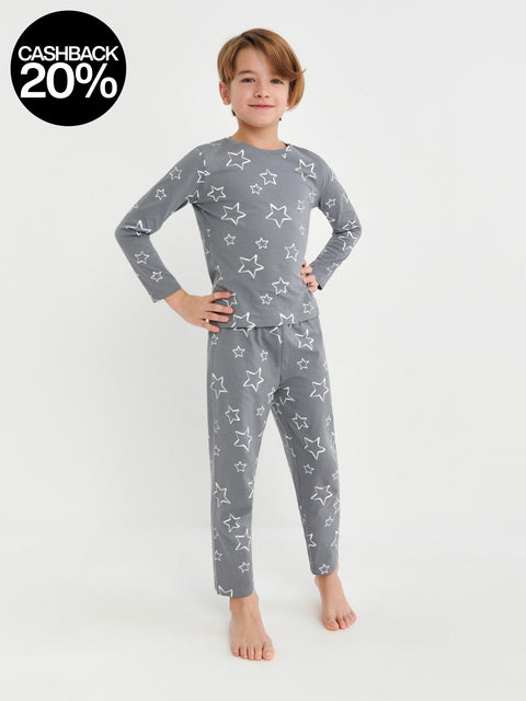 Child wearing a gray star-patterned pajama set on a white background