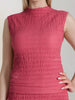 Close-up of a textured pink sleeveless dress on a plain background
