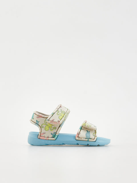 Pair of light blue sandals with floral straps on a white background