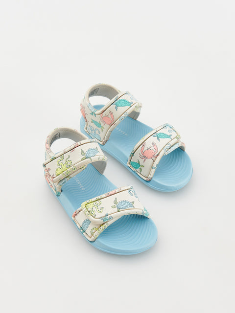 Pair of children's sandals with floral design on a white background