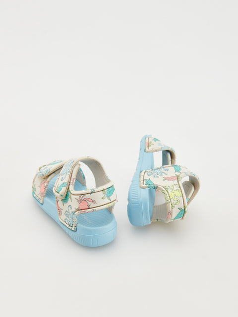 Pair of children's sandals with floral pattern on a light gray background