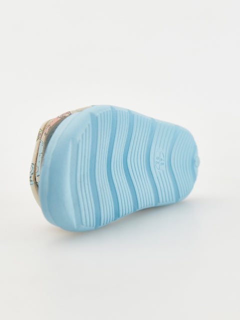 Blue sandal with a textured sole on a light gray background