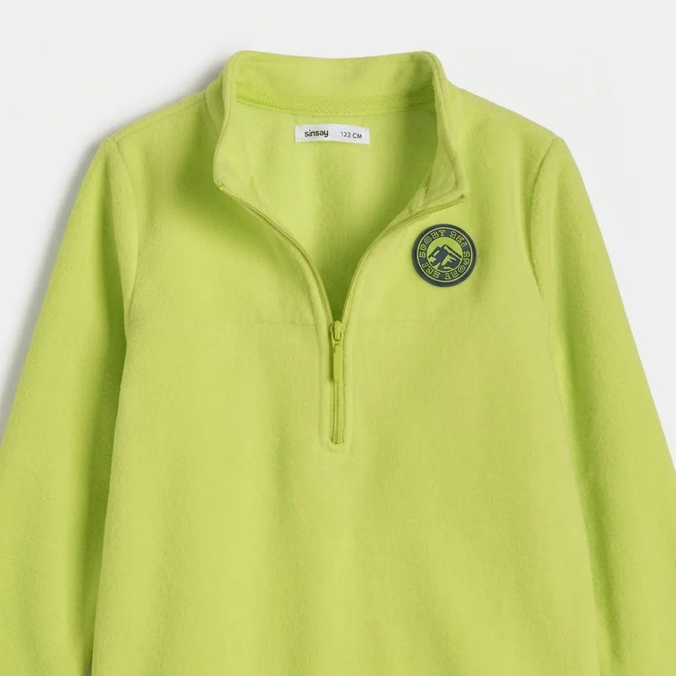 A lime green quarter-zip fleece pullover from Stone Island, featuring a zippered collar and a circular embroidered logo on the left chest, shown against a light gray background.