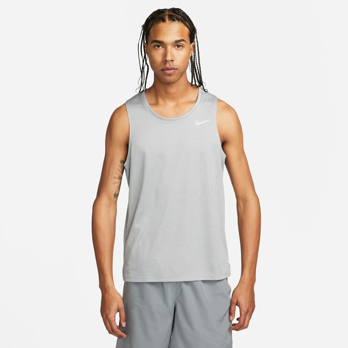 Man wearing a gray Nike tank top and shorts on a white background