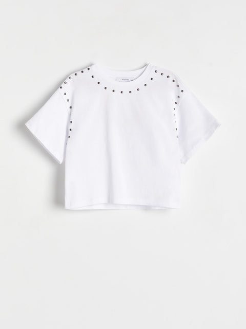 White crop top with black stud details on a white background