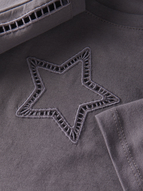 Star-shaped embroidery on a dark fabric surface