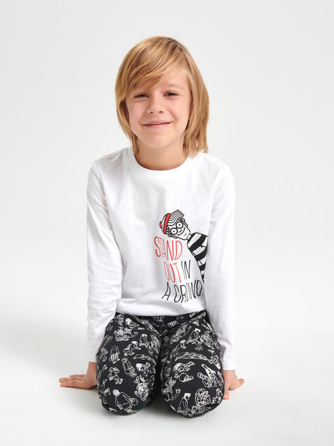Child wearing a white long-sleeve shirt with a graphic design and black patterned pants on a white background