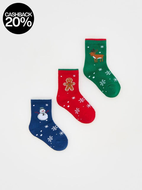 Three Christmas-themed socks in red, green, and blue on a white background