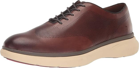 Brown leather shoe with beige sole on a white background