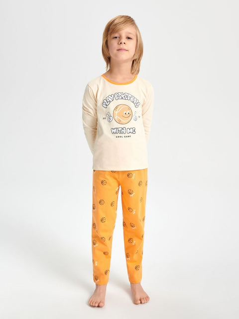 Child wearing a cream long-sleeve top and orange pants with a moon design on a white background