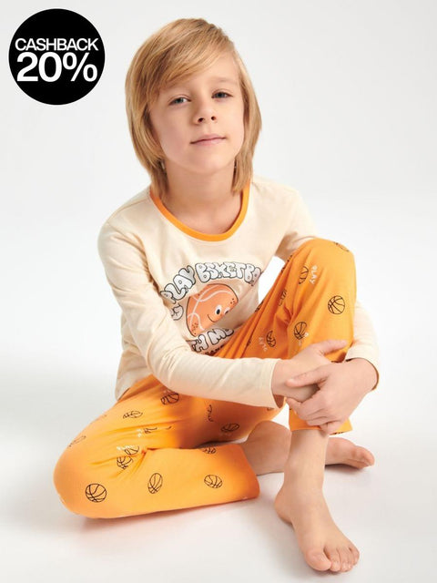 Child wearing a cream and orange pajama set with cartoon design on a white background