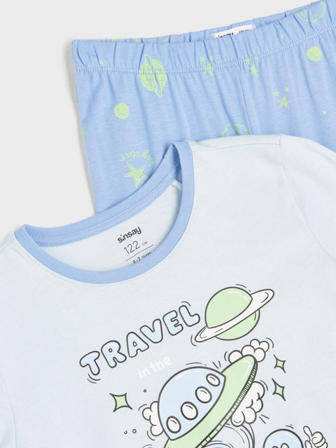Children's t-shirt with space-themed design and blue shorts with planet pattern.
