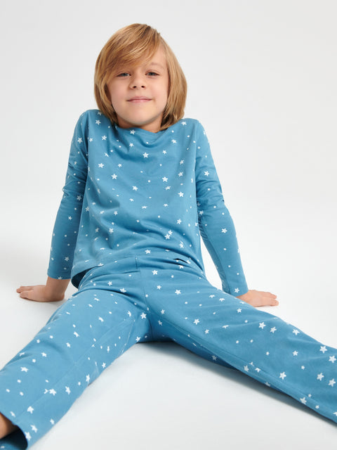 Child wearing blue pajamas with white star patterns on a white background