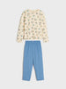 Children's pajama set with patterned top and blue pants on a white background