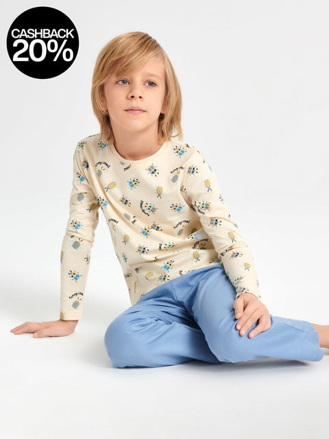 Child wearing a patterned long-sleeve shirt and blue pants on a white background