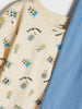 Beige t-shirt with insect pattern and blue fabric next to it