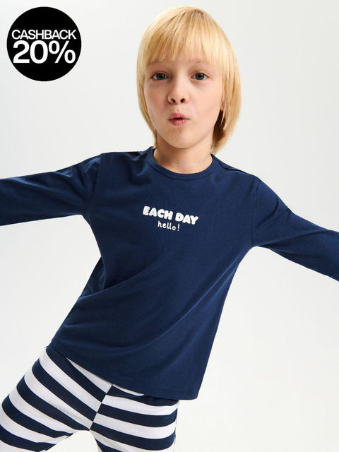 Child wearing a navy blue long-sleeve shirt with text and striped pants on a white background