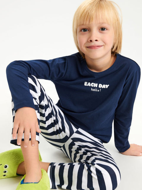 Child wearing navy long-sleeve shirt with 'Each Day Hello!' text and zebra-striped pants on a white background