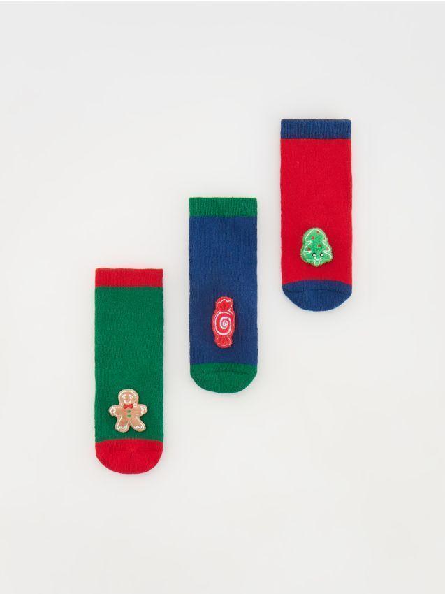 Three pairs of colorful socks with festive designs on a white background