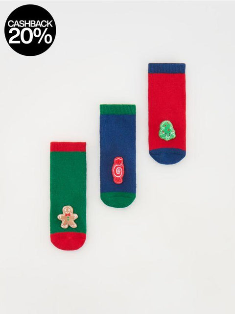 Three pairs of colorful socks with festive designs on a white background