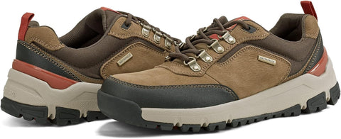 Pair of brown hiking shoes with red accents on a white background