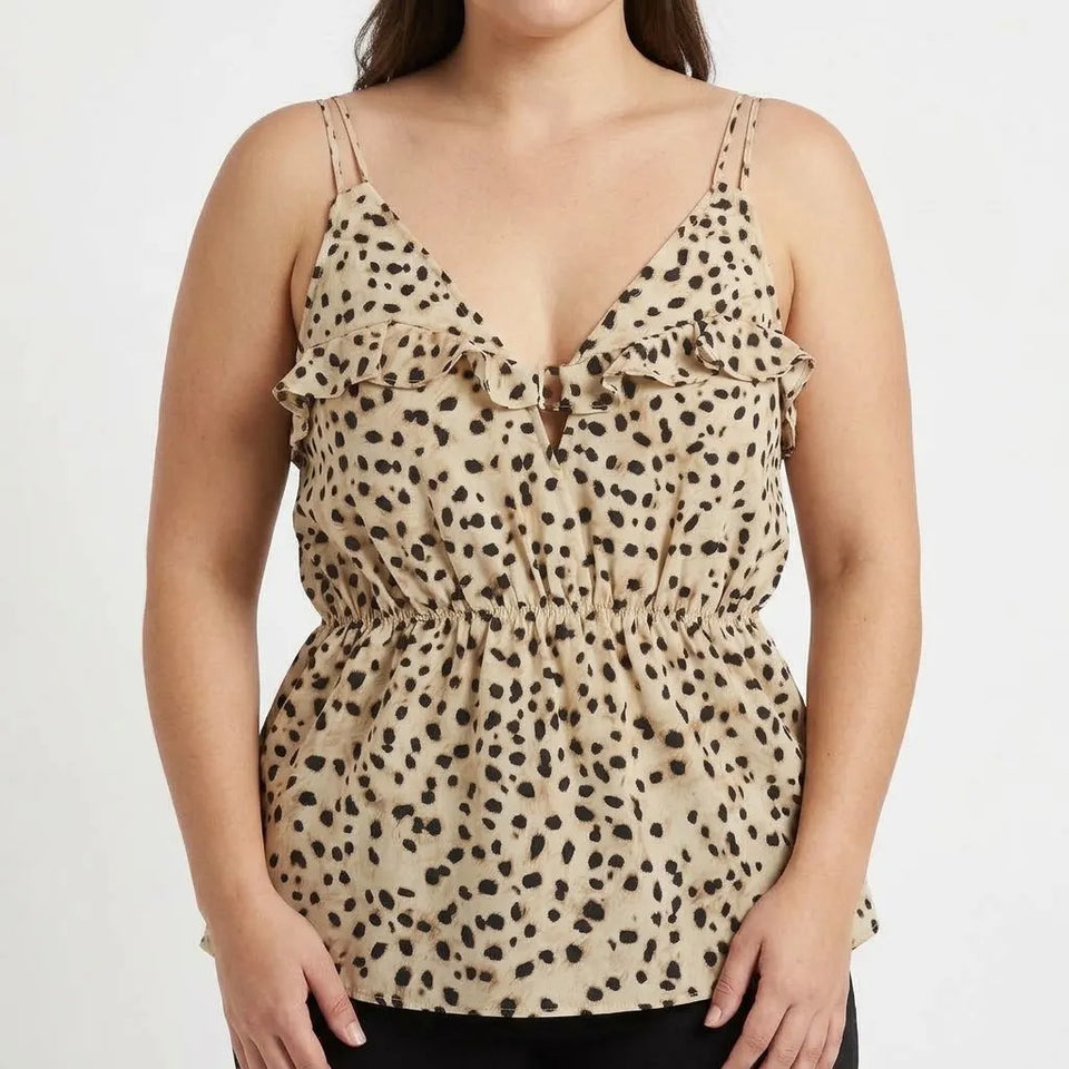 A woman wearing a beige camisole top with a black leopard print pattern, ruffled straps, and a gathered waist, shown against a plain white background.