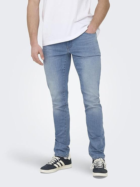 Person wearing light blue jeans and black sneakers on a white background