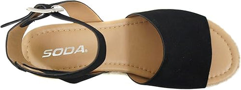 Black sandal with 'SODA' branding on a beige background
