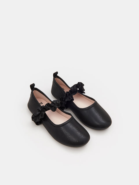 Pair of black shoes with bow details on a white background