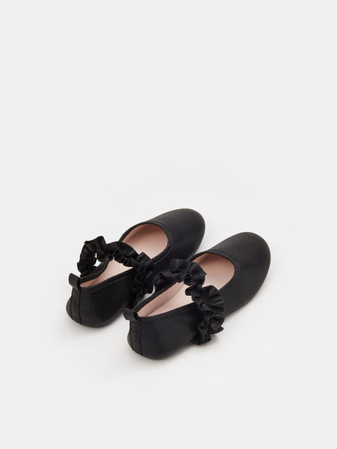 Pair of black shoes with floral details on a white background