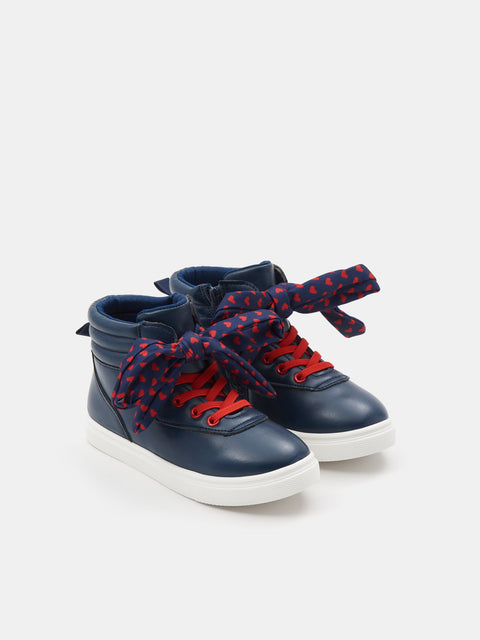 Navy high-top sneakers with red laces and blue polka dot accents on a white background