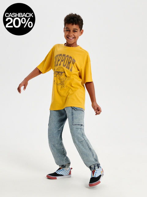 Child wearing a yellow t-shirt with text and graphics, standing on a white background